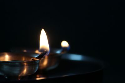 Close-up of illuminated diya against black background