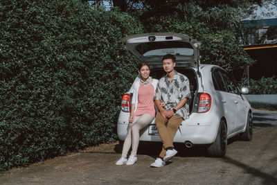 Couple sitting in car trunk