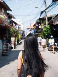 Rear view of woman walking on street in city