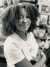 Portrait of teenage girl with curly hair standing in store