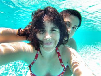 Portrait of smiling mother and son in swimming pool
