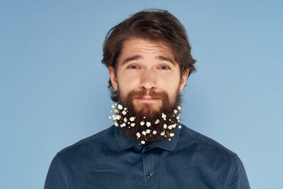 Portrait of young man against blue background