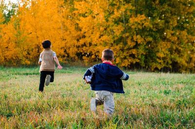 Rear view of people walking on street during autumn