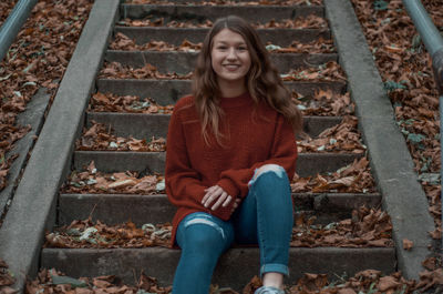 Portrait of a smiling girl sitting on staircase