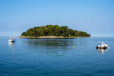 Small island at the croatian coast with some sailing ships