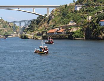 Nautical vessel on bridge over sea against sky