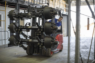 Worker moving equipment riding forklift