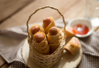 High angle view of sausages in wicker basket on table