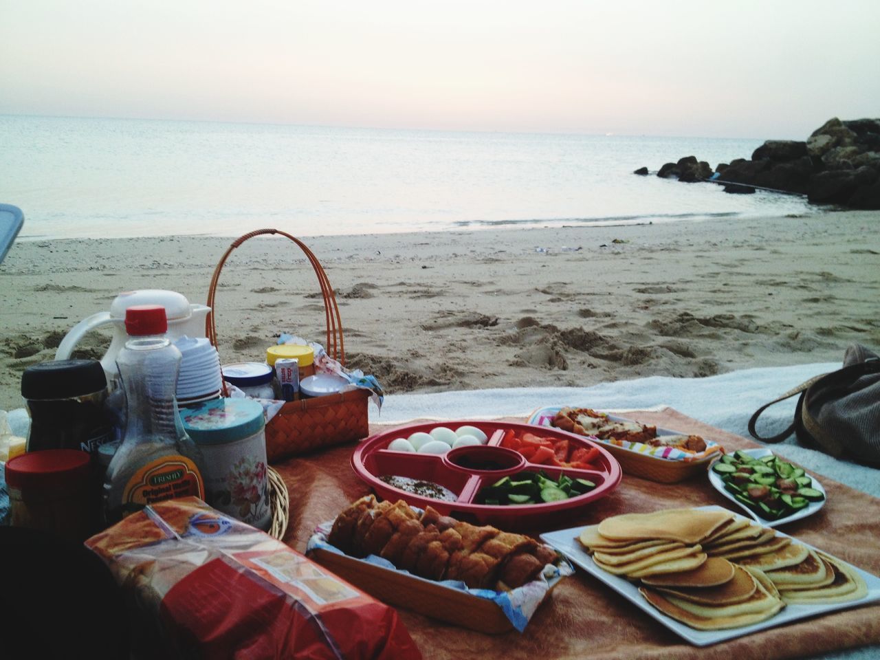 sea, horizon over water, beach, water, table, food and drink, shore, tranquil scene, sand, tranquility, still life, absence, drink, scenics, beauty in nature, sky, nature, freshness, plate, day