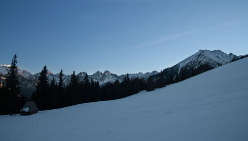 Scenic view of snow mountains against clear blue sky