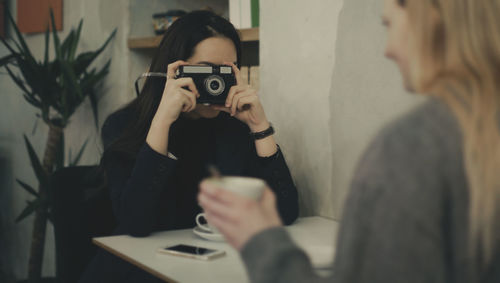 Woman take a picture with a vintage camera