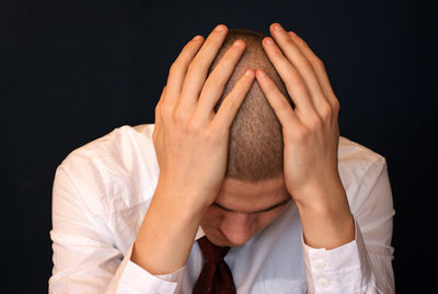 Tensed man against black background