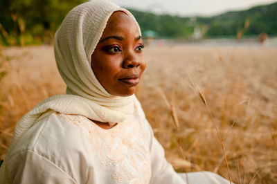 Portrait of young woman standing on field