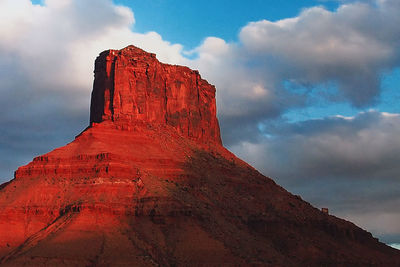 Low angle view of red rock formation against cloudy sky