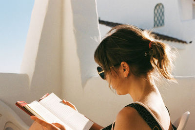 Side view of young woman reading book