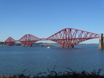 View of bridge over river against blue sky