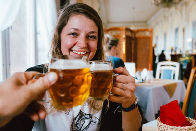 People toasting drinks in glass at restaurant