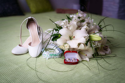 Wedding shoes, garter, wedding rings and a bouquet of flowers