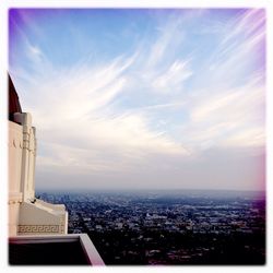 Cityscape against cloudy sky