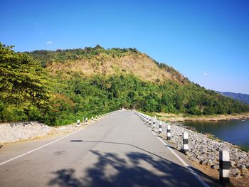 View of road by lake against sky