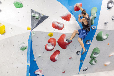 Low angle view of man climbing on wall