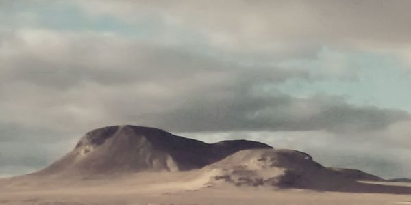 Scenic view of mountains against cloudy sky