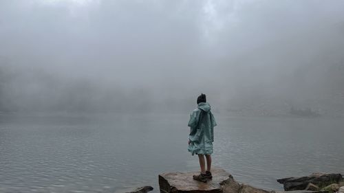 Cloudy lake side man standing near edge