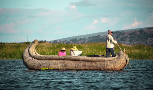 People on boat against sky