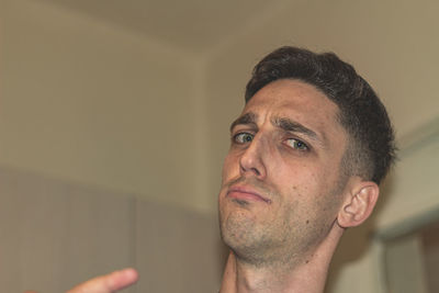 Close-up portrait of man wearing eyeglasses at home