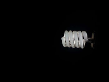 Close-up of light bulb against black background