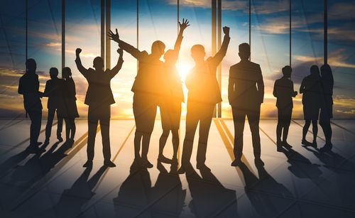 Silhouette people standing against sky during sunset