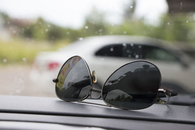 Close-up of sunglasses on car window