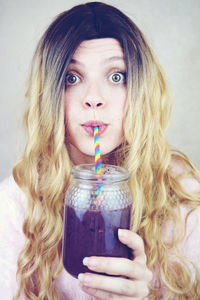 Portrait of woman drinking juice from glass jar