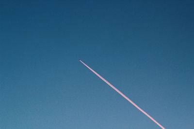 Low angle view of vapor trail against blue sky
