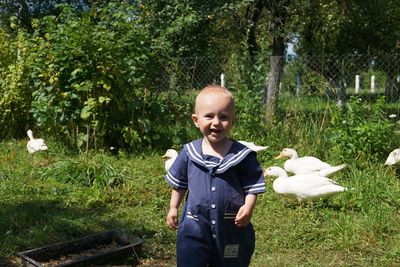 Portrait of smiling baby boy walking at back yard