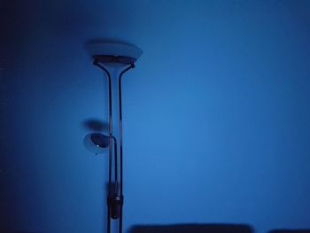 Low angle view of light bulbs on table against blue background