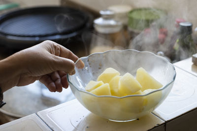 Midsection of person preparing food in bowl on table