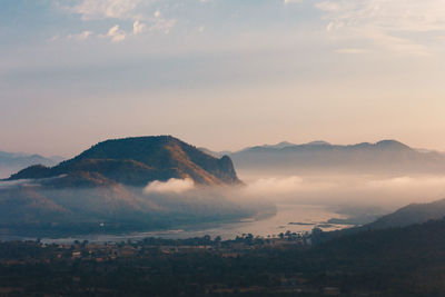 Scenic view of sea and mountains against sky during sunset