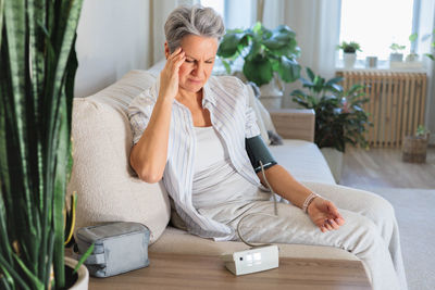 Young woman using phone while sitting at home
