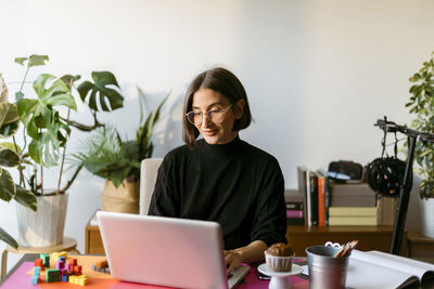 Female freelancer working on laptop sitting at home