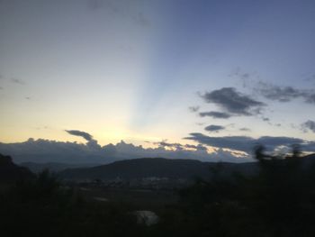 Scenic view of silhouette mountains against sky at sunset