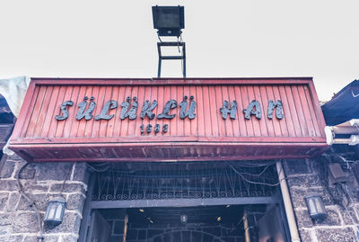 Low angle view of text on building against sky