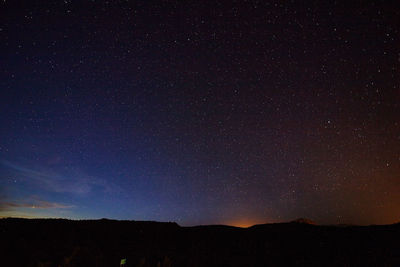 Scenic view of silhouette landscape against sky at night