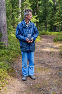 Man holding a container with wild blueberries in the forest. not enough has been collected