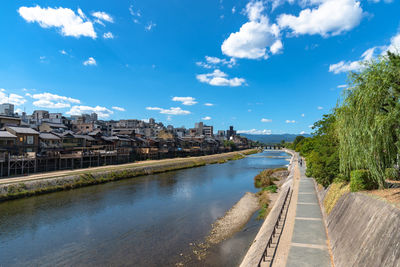 River amidst buildings in city against sky