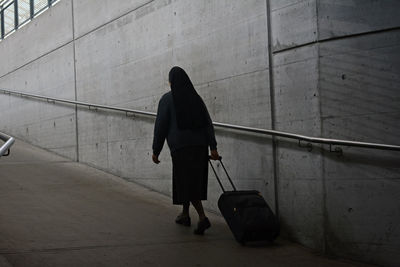 Rear view of woman walking on wall