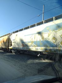 Train on railroad tracks against clear blue sky