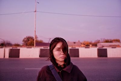 Portrait of beautiful woman standing against sky during sunset