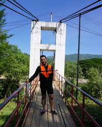 Portrait of man standing on footbridge