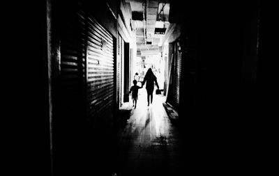 Silhouette people walking in corridor of building